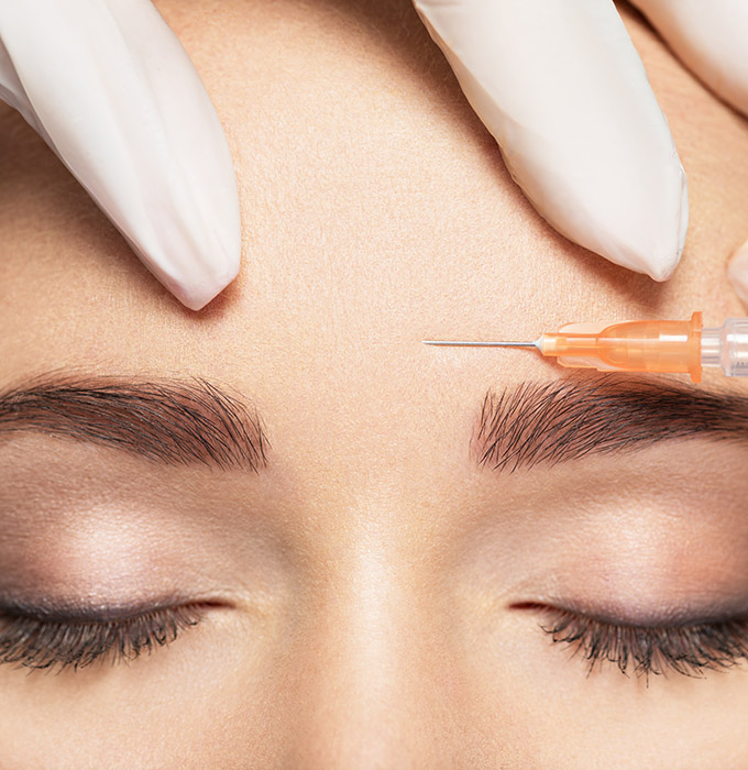 Woman getting cosmetic injection of botox near eyes Woman getting cosmetic injection of botox near eyes